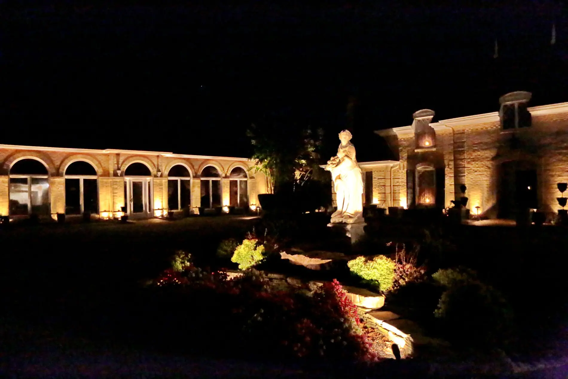 Arched brick residence lit across the front elevation